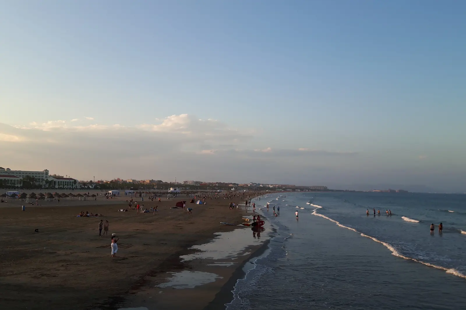 Malvarrosa-stranden i Valencia i tusmørket, hvor havet skyller sandet, og hotellerne langs kysten